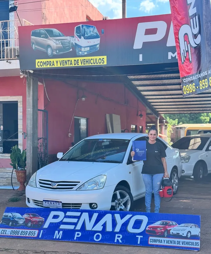 Entrega de un Toyota blanco a una clienta frente al predio de Penayo Import